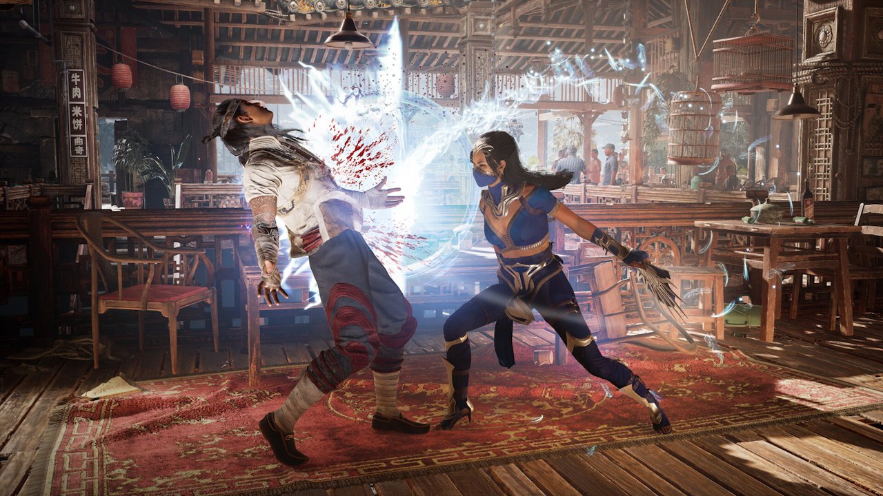 september video games 2023 mortal kombat 1 - two figures fight. The lady on the right slices across the chest of a man on the right, with blood and magical blue sparks flying out of the impact